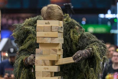 man  camouflage suit removes blocks   jenga tower  caseking booth creative commons bilder