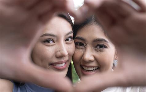 asian lesbian couple in a romantic mood making heart shaped hand