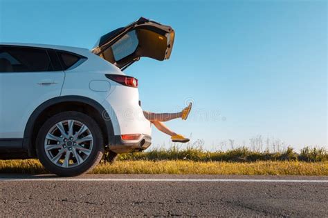 Woman Legs Stick Out Of Suv Car Trunk Parked At Roadside Of Speedway