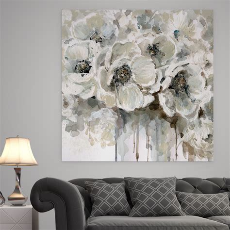 a living room scene with focus on the grey couch and white flowers