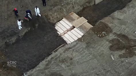 drone footage shows bodies  caskets  buried  hart island