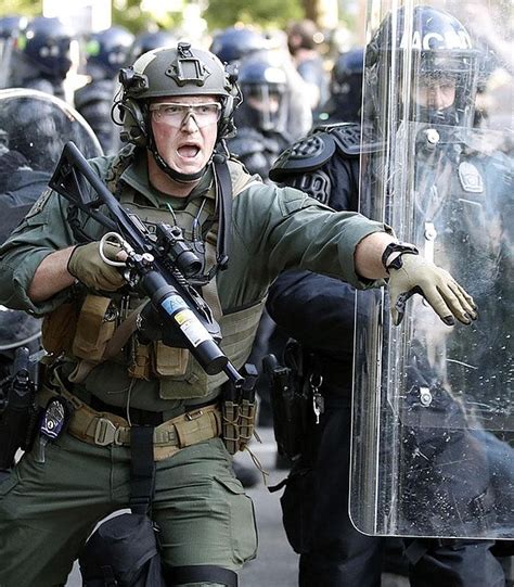 critics say tensions escalated by police wearing riot gear