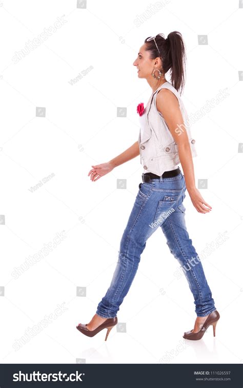 Side View Of A Casual Woman Walking Isolated Over A White