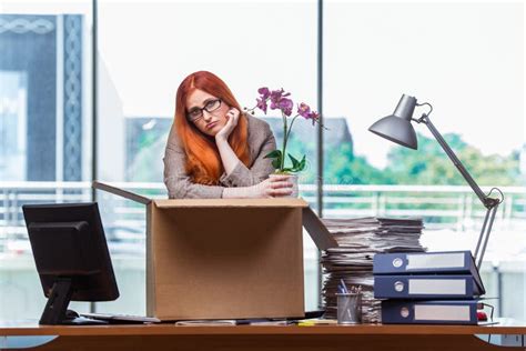 the red head woman moving to new office packing her belongings stock