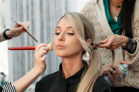 A Hairdresser And A Makeup Artist Together Prepare A Beautiful Model