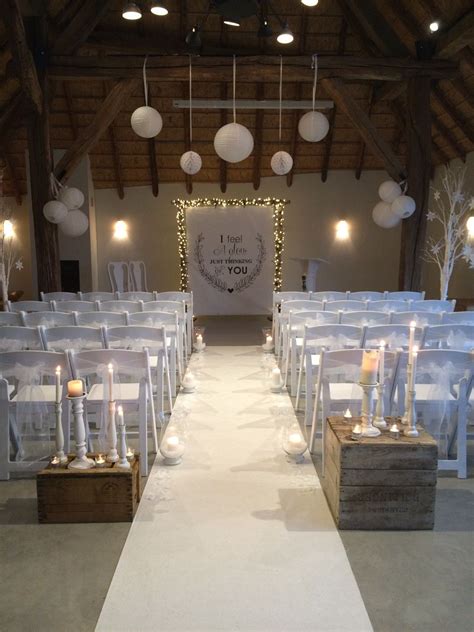 aisle  lined  white chairs  lit candles   elegant