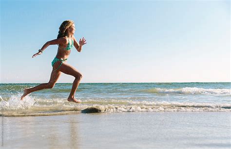 Young Girl Running At The Beach By Stocksy Contributor Raymond
