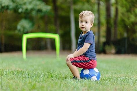 cute young boy sitting   soccer ball  stocksy contributor jakob lagerstedt stocksy