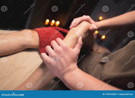 Male Masseur Doing Sports Massage Of The Lower Leg To The Athlete In