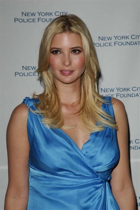 A Blonde Woman In A Blue Dress Posing For The Camera With Her Hand On