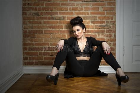 Moody Elegant Woman Sitting On A Parquet Floor Stock Image