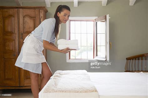 Hotel Maid In Room With Pile Of Towels Photo Getty Images