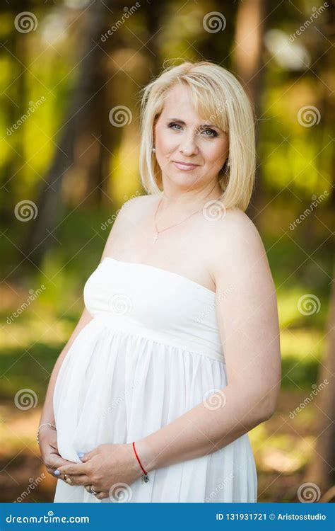 Closeup Portrait Of Pregnant Woman In Her Late 30`s In White Long Sheer