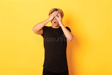 Portrait Of Embarrassed Asian Guy With Blond Hair Gasping Startled And