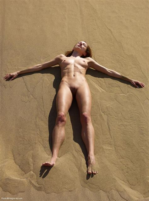 long legs skinny model laying naked in the sand from