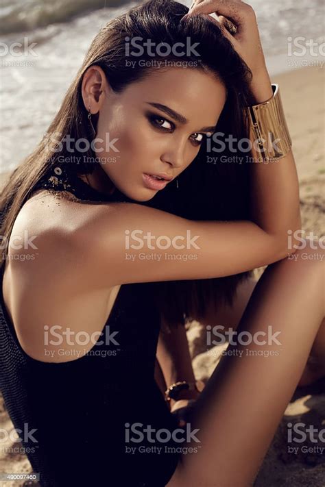 dziewczyna z ciemnych włosów i garbowane skin stwarzające na plaży