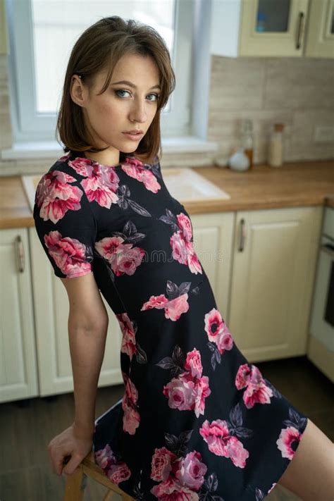 Beautiful Young Brunette Woman In Dress Alone In The Kitchen At Home