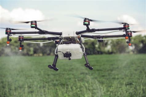 agriculture drone spraying water  pesticides  grow  green field stock photo image