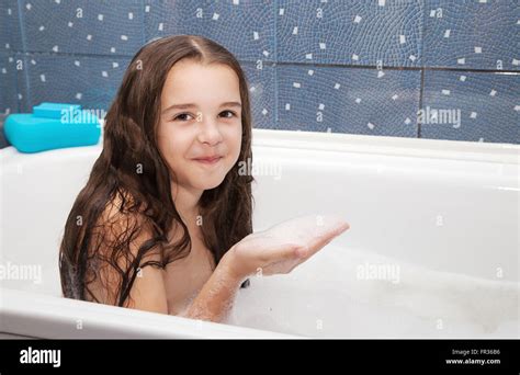 Little Smiling Girl With Long Brown Hair Taking A Bath With Shampoo