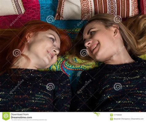 Two Pretty Lesbians Girlfriends Kissing And Hugging In A Cozy