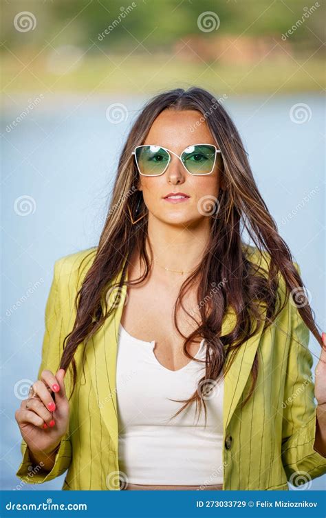 Retractive Young Female Model Posing In Green Tinted Sunglasses Stock