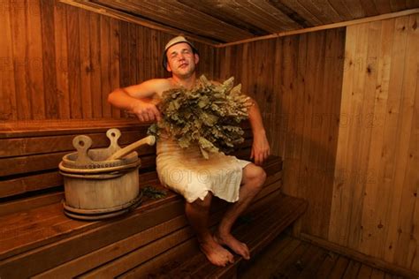 A Man Rubbing Himself With A Birch Branch At A Banya Sauna At The