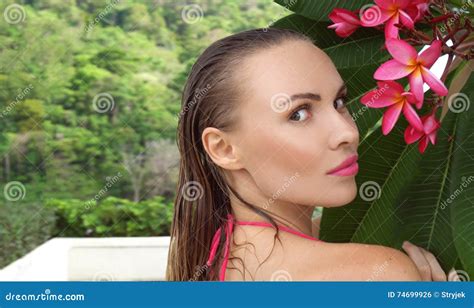 Young Woman Wearing Bikini With Wet Hair And Tree Flower On A Sunny Day