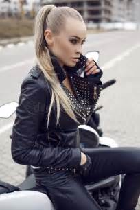 girl with long blond hair in leather jacket posing on