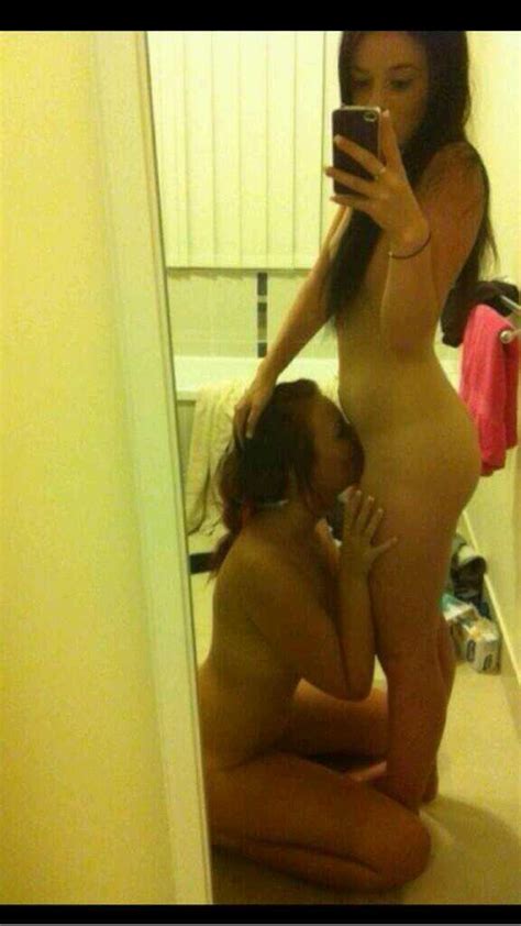 takes a selfie while her naked friend licks her pussy