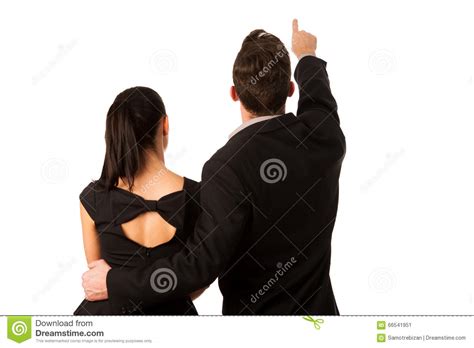 Confident Business Couple Standing Next To Each Other Pointing Stock