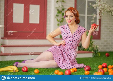 beautiful redheaded pin up girl in pink polka dot dress