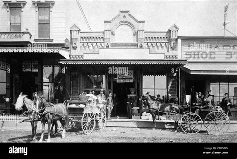 men standing   horse drawn carriages  front  shops  north side