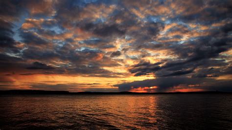 sunset   water   lakeshore  dramatic cloudy sky stock