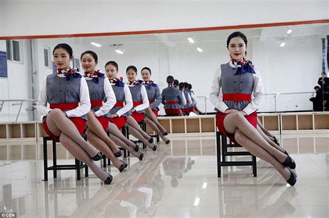 chinese flight attendants practise graceful grin with a chopstick