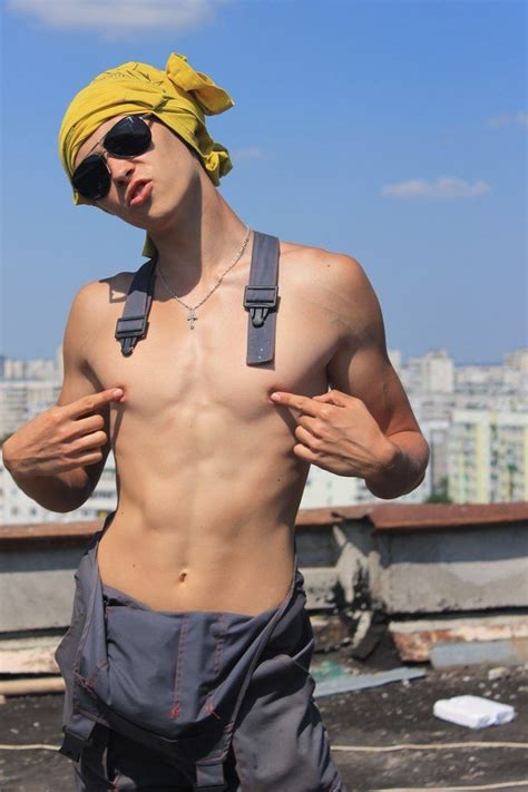 A Shirtless Man With No Shirt On Standing In Front Of A Cityscape