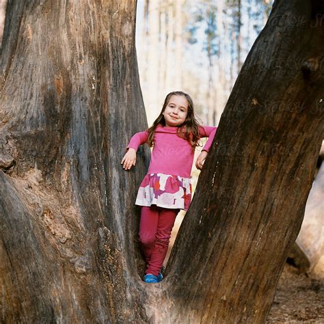 Cute Young Girl Standing In Tree By Stocksy Contributor Jakob