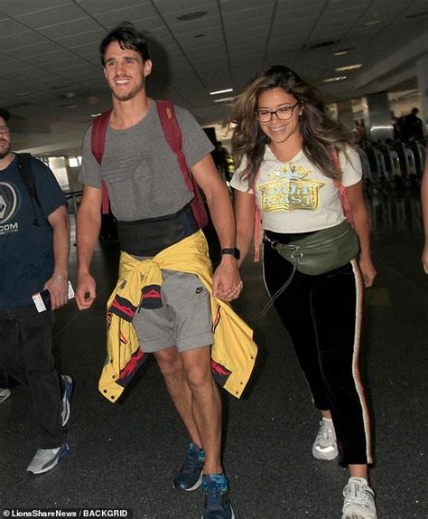 gina rodriguez smiles as she walks hand in hand with her
