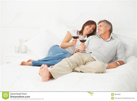 happy mature couple lying on their bed stock image image