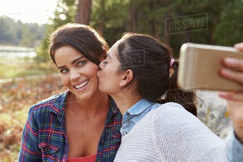 Lesbian Couple In The Countryside Kiss And Take A Selfie