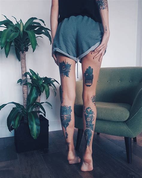 A Woman Standing In Front Of A Green Chair With Tattoos On Her Legs And Leg