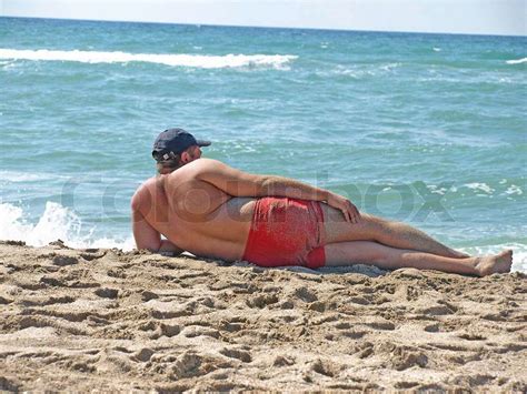 man lying   sand   beach     distance stock photo colourbox