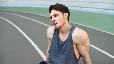 close   tired runner sitting  track  running workout exhausted man resting outdoors