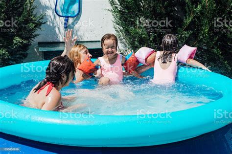 a couple of lesbian women bathe in the pool with their daughters stock