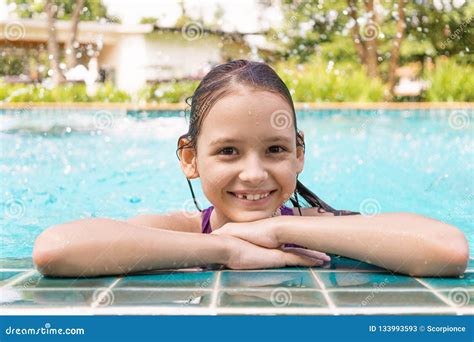 cute smiling preteen girl at swimming pool edge travel vacation stock