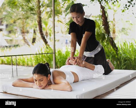 a woman receives a thai massage in an outdoor cabana by