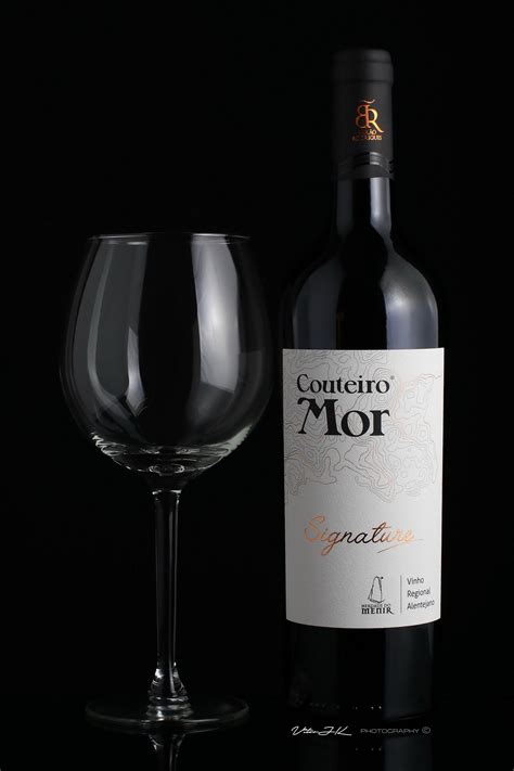 wine glass  bottle sitting       black surface   dark background