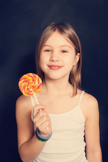 Premium Photo Young Girl With Lollipop On Background