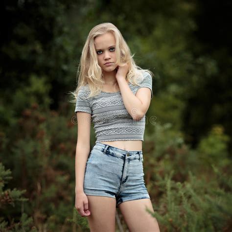 bautiful blonde tiener alleen in het hout stock foto