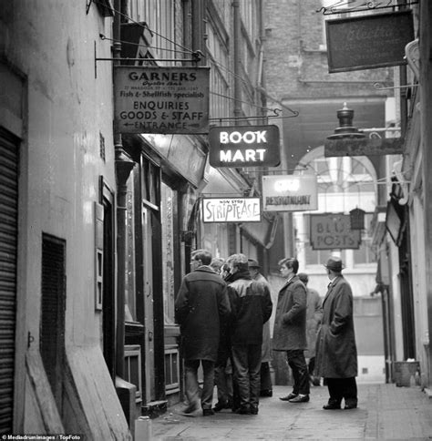 black  white photograph  people walking   street  front  bookshops