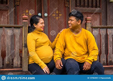 Indonesian Pregnant Wife Sits With Her Husband Outside